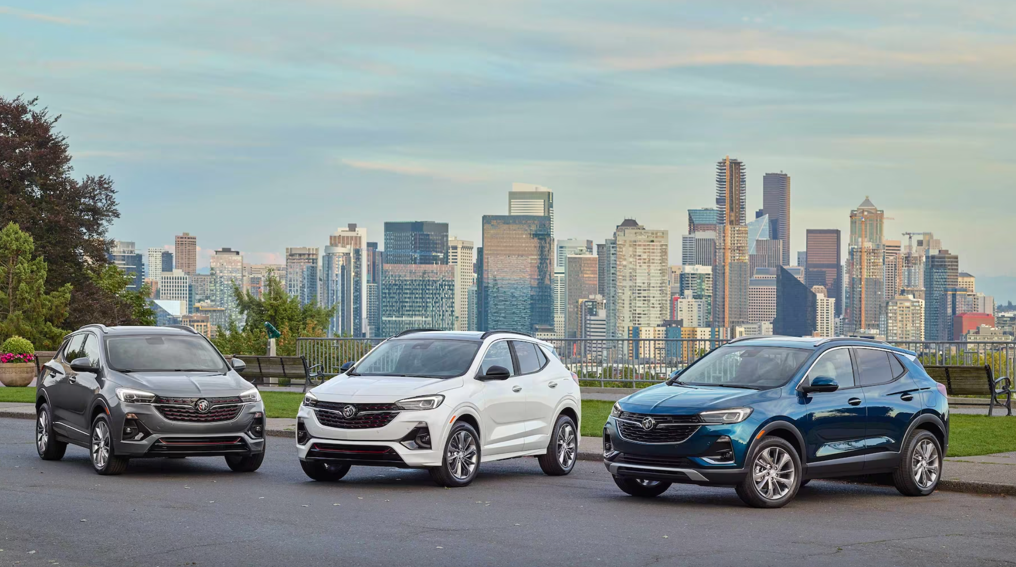 A trio of 2023 Buick Encore GX models lined up with a city backdrop